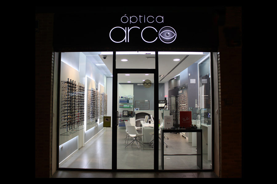Fachada nocturna de Óptica Arco